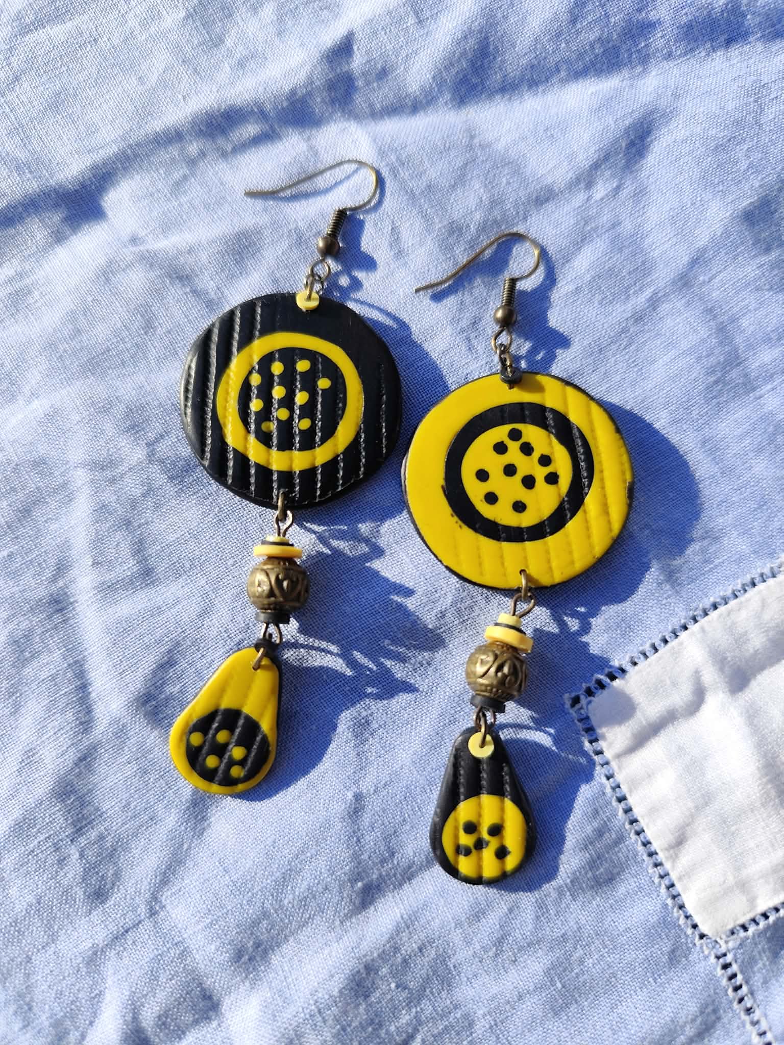 boucles d’oreilles asymétriques noir et jaune à pois en argile polymère avec perle métal longues graphiques