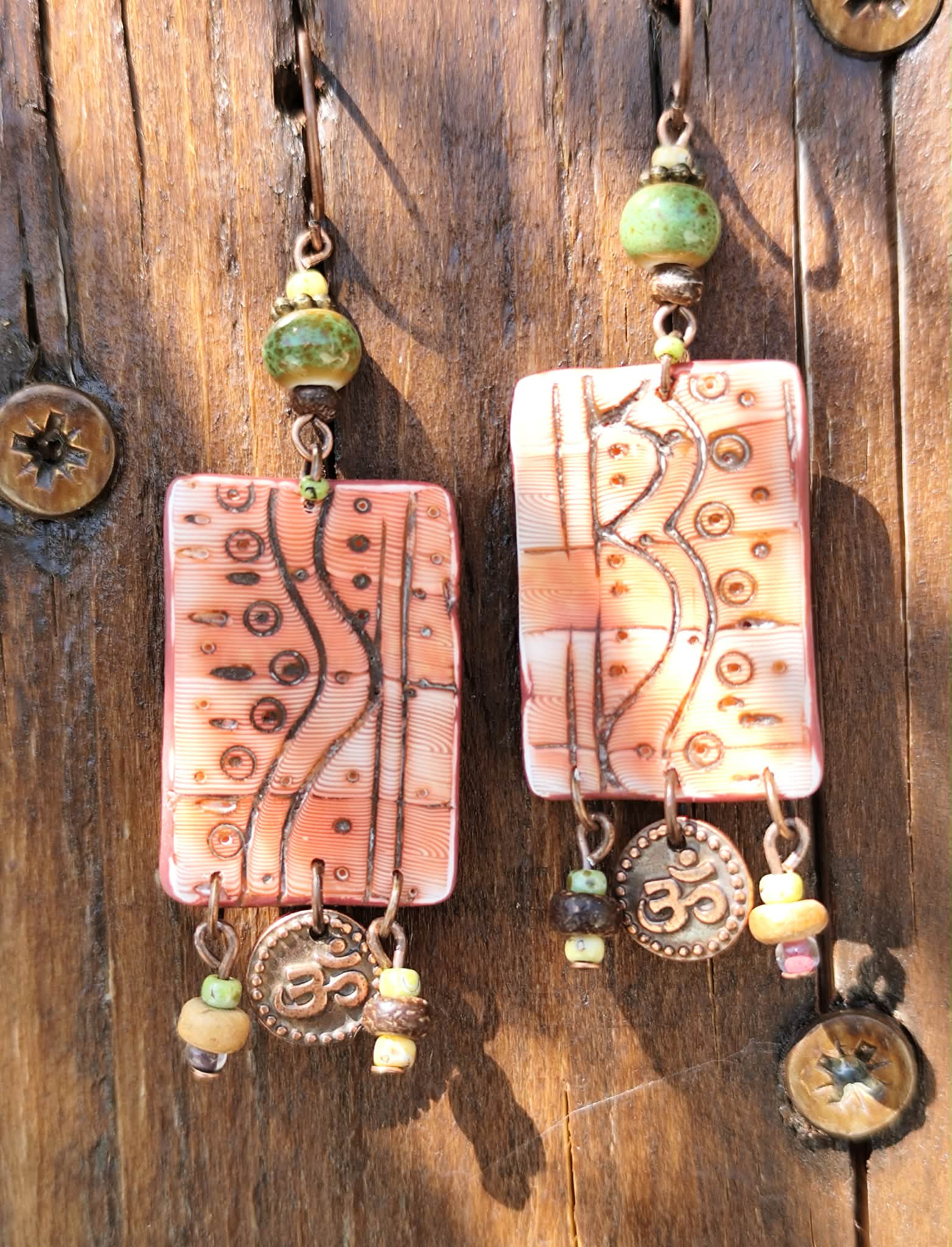 Boucles d’oreilles paysage terre rouge du Salagou avec motifs gravés, perles vertes en céramique, coco et breloque ohm artisanales et légères